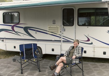 person sitting in chair in front of an RV